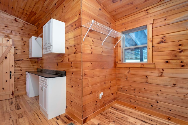 interior space with wood walls, lofted ceiling, light hardwood / wood-style flooring, and wooden ceiling