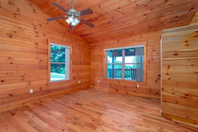 empty room featuring lofted ceiling, wooden walls, wooden ceiling, and light hardwood / wood-style floors