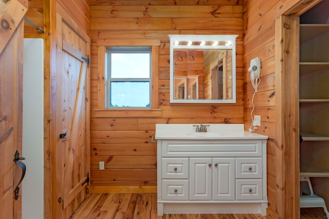 bathroom featuring wood walls, vanity, and wood-type flooring