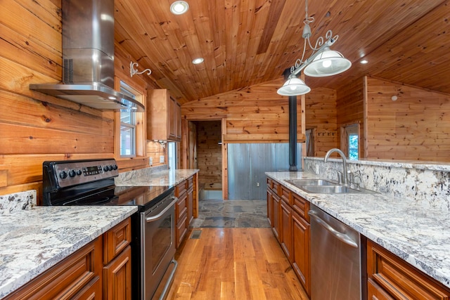 kitchen featuring lofted ceiling, sink, wooden walls, island range hood, and stainless steel appliances