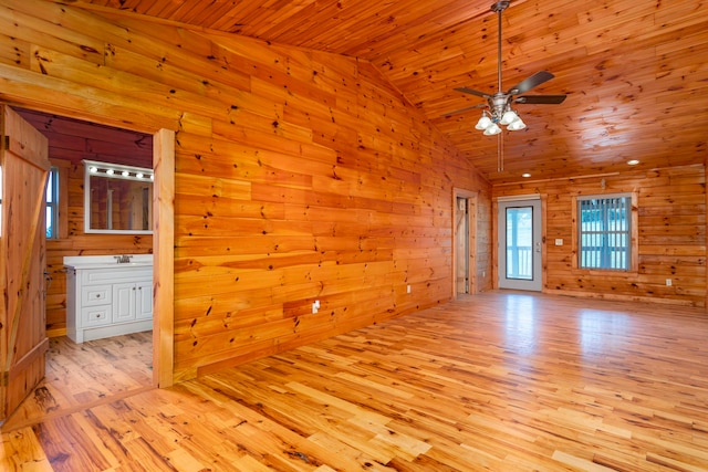 spare room featuring ceiling fan, light hardwood / wood-style flooring, wood walls, vaulted ceiling, and wood ceiling