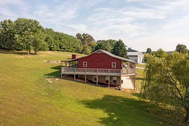 back of property with a deck and a yard