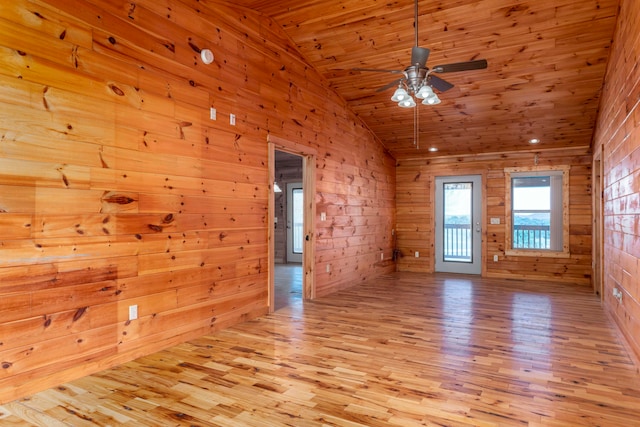 empty room featuring ceiling fan, light hardwood / wood-style floors, lofted ceiling, wooden walls, and wood ceiling