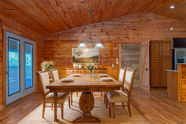 dining area with wood walls, light wood-type flooring, and wooden ceiling