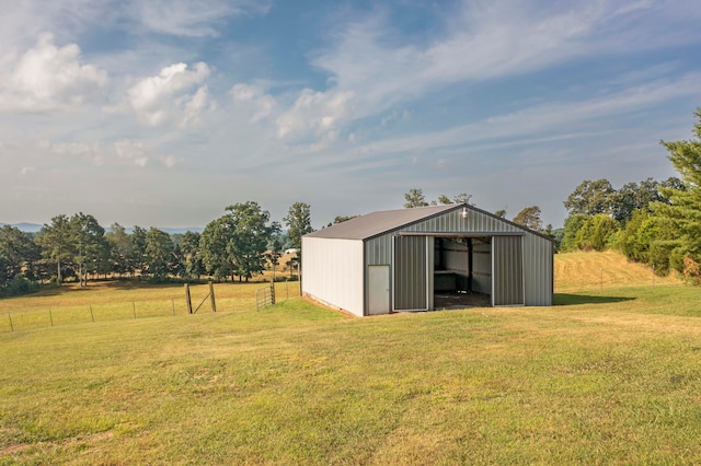 view of outdoor structure featuring a rural view and a lawn