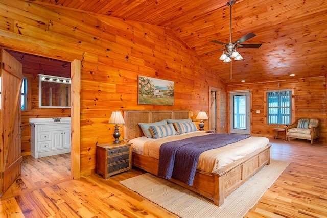 bedroom featuring ensuite bath, ceiling fan, wood walls, wood ceiling, and light wood-type flooring