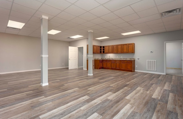 unfurnished living room featuring hardwood / wood-style floors, a paneled ceiling, and sink