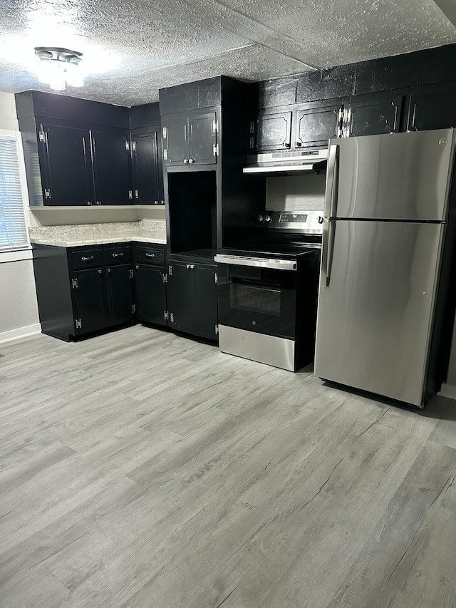 1453 Barnes St NE, Cleveland, TN 37311 - kitchen featuring stainless steel appliances, dark cabinetry, light wood finished floors, under cabinet range hood, and a textured ceiling