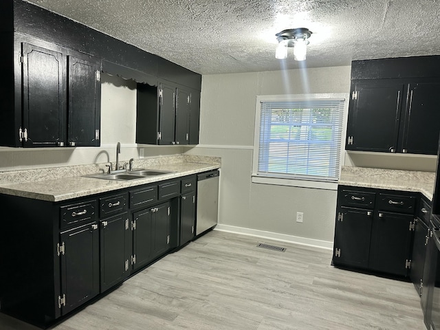 1453 Barnes St NE, Cleveland, TN 37311 - kitchen with dark cabinets, dishwasher, a textured ceiling, light wood-style floors, and light countertops