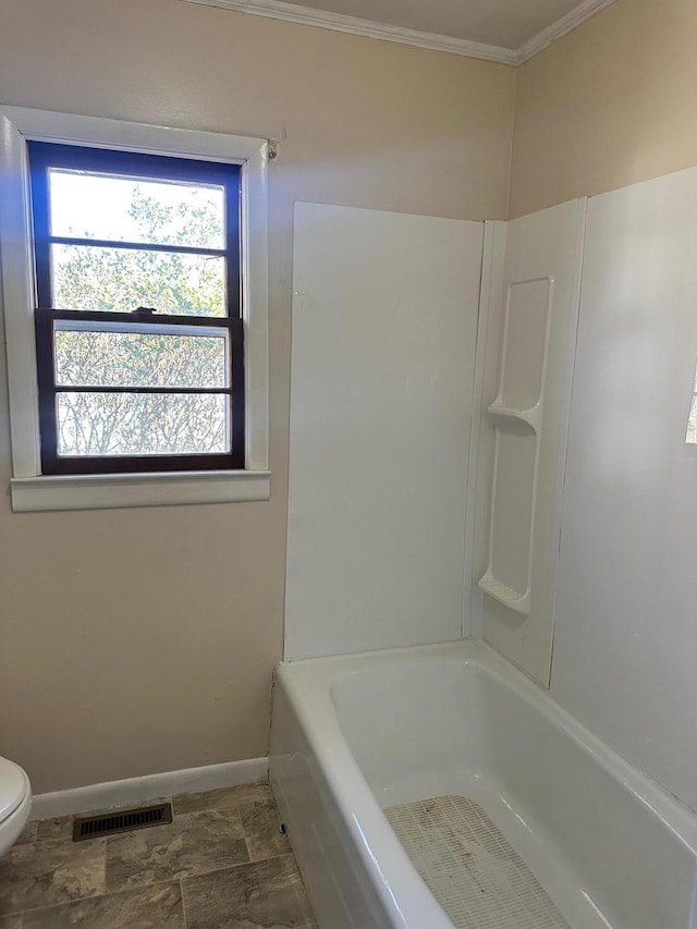 bathroom featuring ornamental molding, shower / washtub combination, and toilet