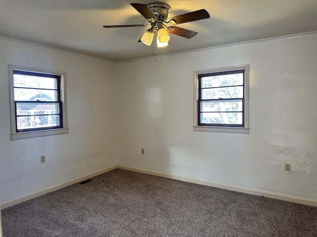 carpeted empty room with ceiling fan, plenty of natural light, and ornamental molding