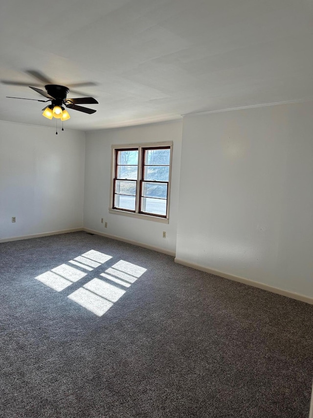 empty room featuring ceiling fan and dark carpet