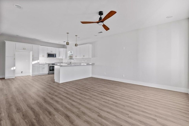 unfurnished living room with ceiling fan, light hardwood / wood-style flooring, and sink