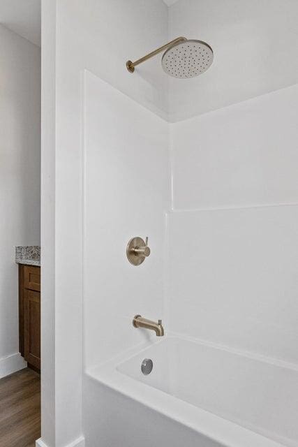 bathroom with vanity, wood-type flooring, and bathtub / shower combination