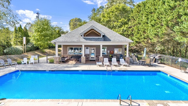 view of swimming pool with an outdoor structure and a patio