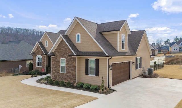 craftsman house with central AC unit and a garage