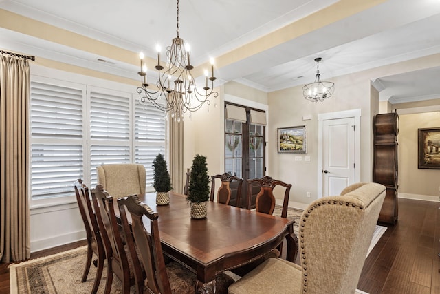 dining room with dark wood-type flooring, an inviting chandelier, ornamental molding, french doors, and a raised ceiling