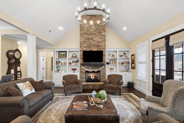 living room with ornate columns, a stone fireplace, high vaulted ceiling, a chandelier, and hardwood / wood-style flooring