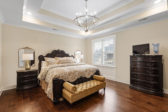 bedroom featuring ornamental molding, dark wood-type flooring, a chandelier, and a tray ceiling