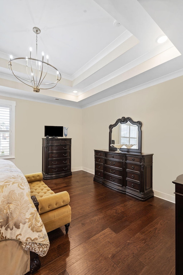 bedroom with dark wood-type flooring, ornamental molding, a raised ceiling, and a notable chandelier