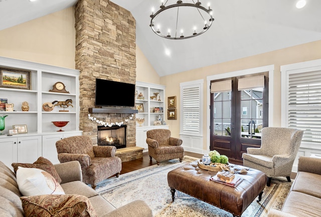 living room with hardwood / wood-style flooring, high vaulted ceiling, a fireplace, and an inviting chandelier