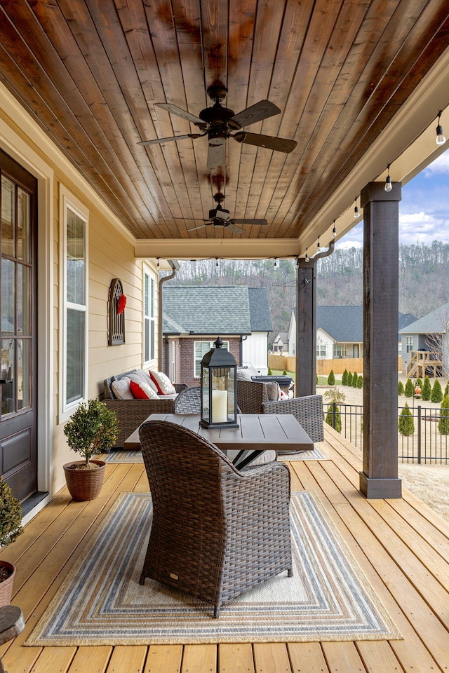 wooden terrace with an outdoor hangout area and ceiling fan