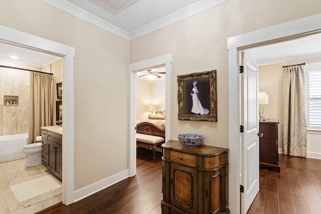 hallway with ornamental molding and dark hardwood / wood-style floors