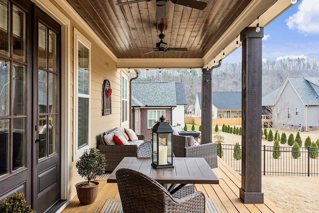 wooden terrace featuring an outdoor structure and ceiling fan