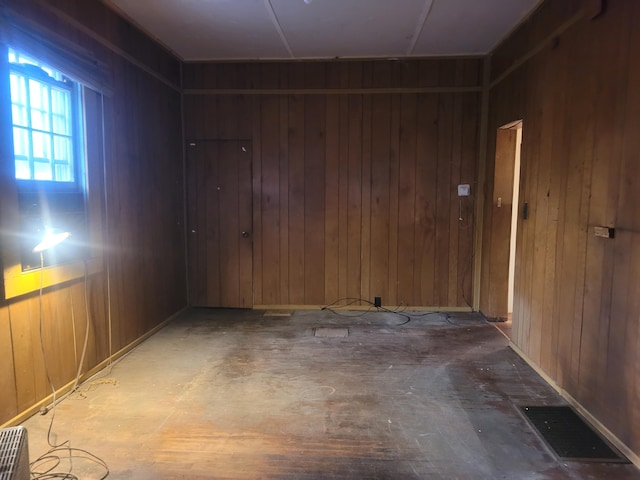 unfurnished room featuring wooden walls