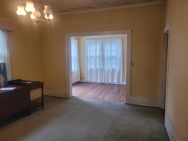 interior space with a chandelier, carpet floors, and crown molding