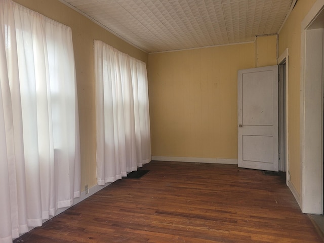 unfurnished room featuring dark hardwood / wood-style flooring and a healthy amount of sunlight