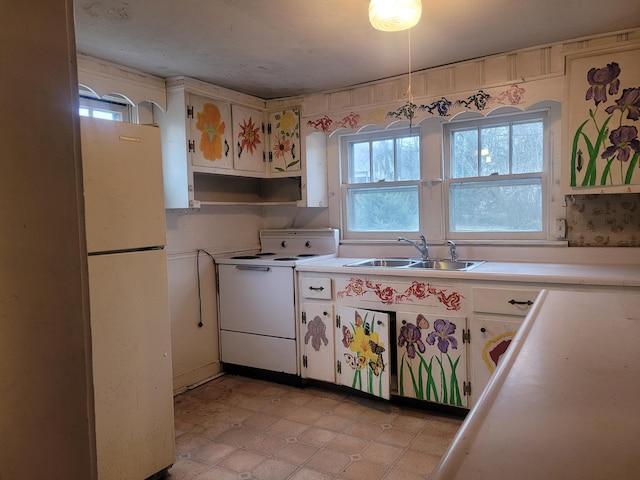 kitchen featuring white cabinets, range, white refrigerator, and sink