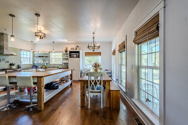 dining room with dark hardwood / wood-style flooring and a chandelier