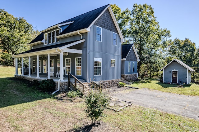 view of front of house with an outbuilding, a front lawn, and covered porch