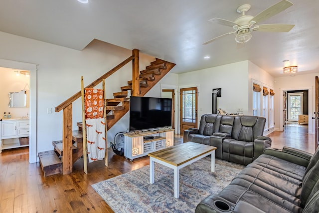 living room featuring hardwood / wood-style floors, ceiling fan, and a wood stove