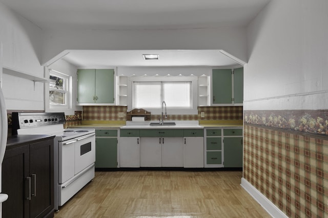 kitchen with green cabinets, light wood-type flooring, and electric stove