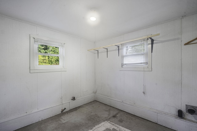 unfurnished room with concrete flooring and wooden walls