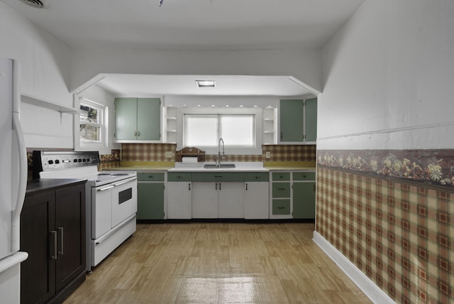 kitchen featuring white appliances, green cabinets, sink, light wood-type flooring, and tasteful backsplash