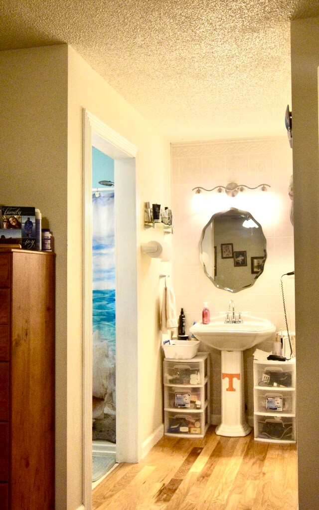 bathroom with hardwood / wood-style flooring, sink, and a textured ceiling