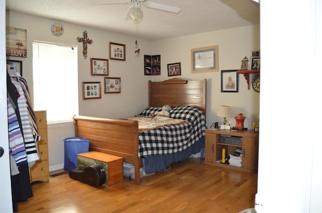 bedroom featuring a textured ceiling, ceiling fan, and light hardwood / wood-style flooring