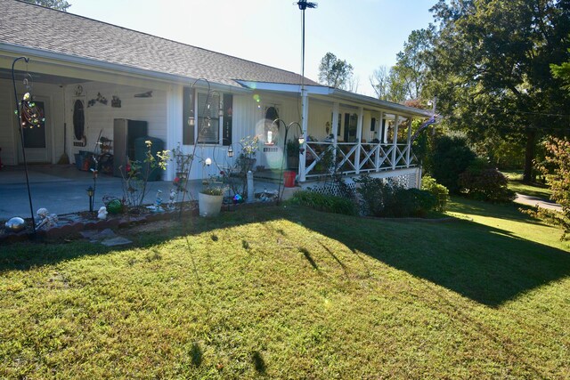 rear view of property featuring covered porch and a lawn