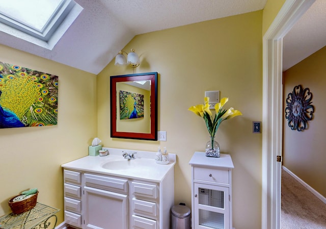 4809 Wind Bluff Cir, Birchwood, TN 37308 - bathroom featuring vanity, lofted ceiling with skylight, baseboards, and a textured ceiling