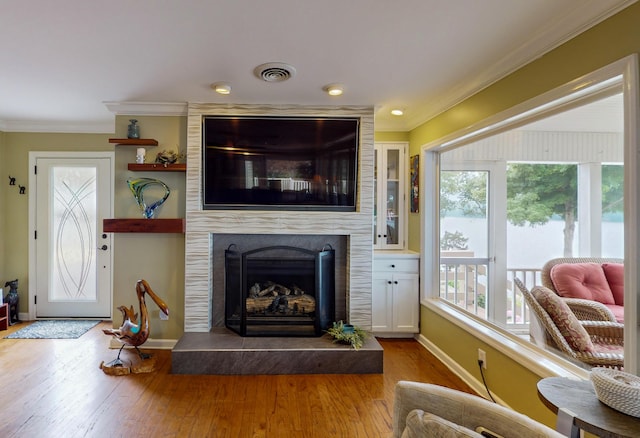 4809 Wind Bluff Cir, Birchwood, TN 37308 - living area with visible vents, wood-type flooring, a large fireplace, crown molding, and baseboards