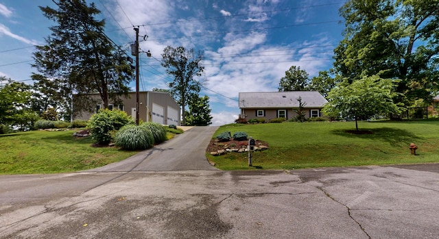 4809 Wind Bluff Cir, Birchwood, TN 37308 - view of front facade featuring an outbuilding, driveway, a detached garage, and a front lawn