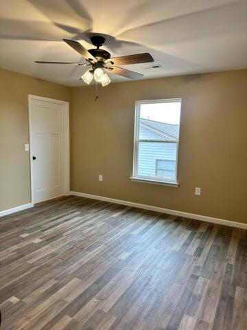 spare room featuring dark hardwood / wood-style flooring and ceiling fan