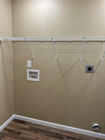 washroom featuring dark hardwood / wood-style floors, hookup for a washing machine, and electric dryer hookup