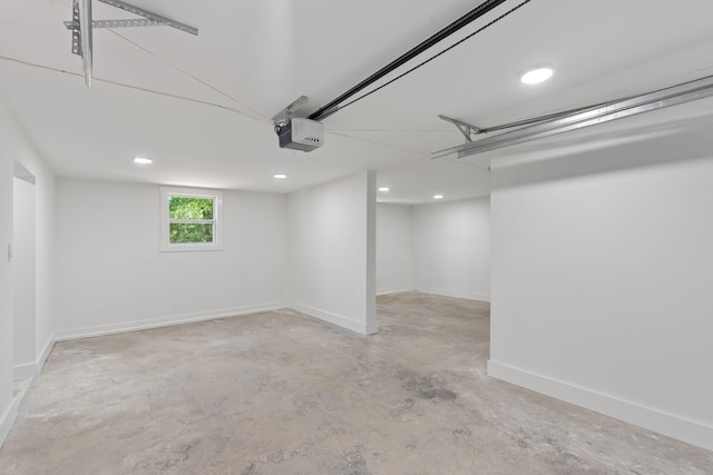 basement featuring a garage, baseboards, and recessed lighting