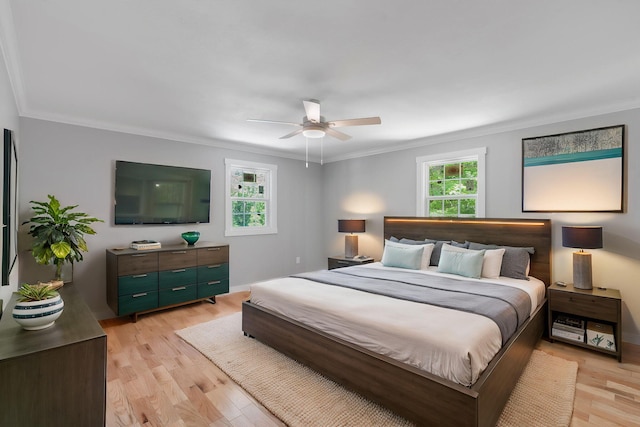 bedroom featuring crown molding, multiple windows, and light wood-style flooring