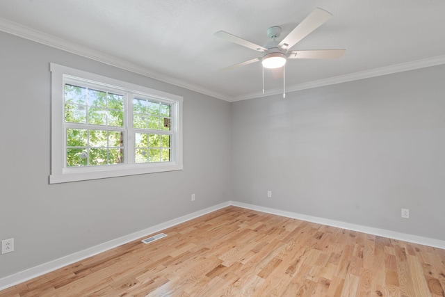 spare room with ceiling fan, light wood-style flooring, baseboards, visible vents, and ornamental molding