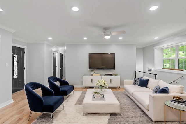 living room featuring light wood-style flooring, recessed lighting, baseboards, a ceiling fan, and ornamental molding